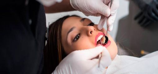 Una mujer está siendo examinada por un dentista.