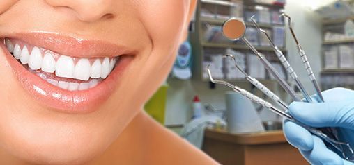 Una mujer sonríe mientras un dentista le examina los dientes.