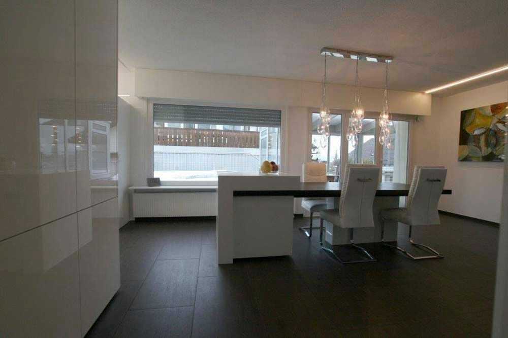 Ein Esszimmer mit Tisch und Stühlen und einem Fenster