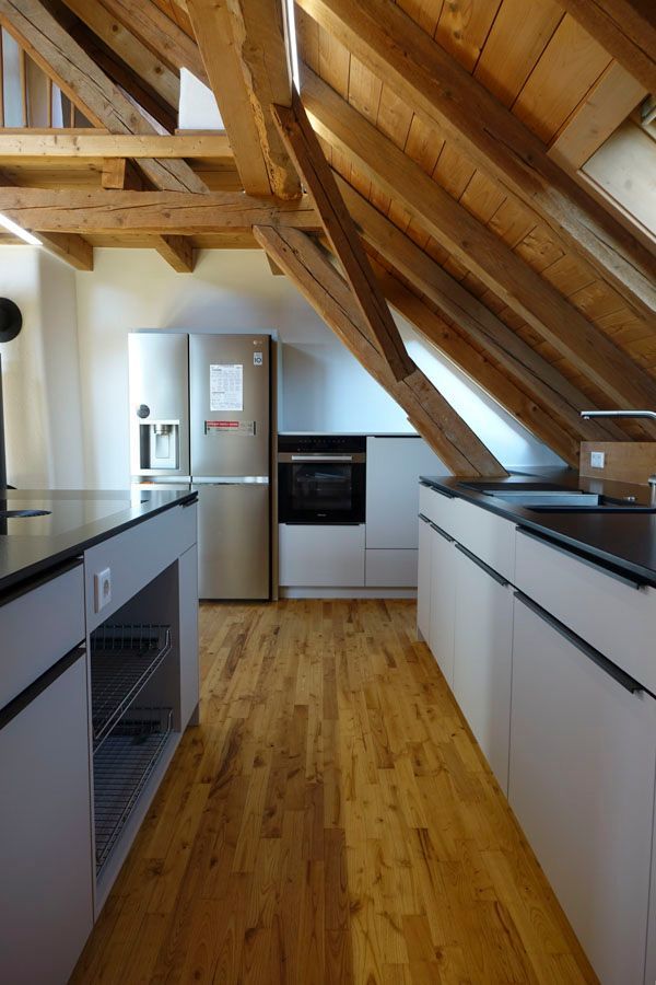 Eine Küche mit Holzdecke und Edelstahlkühlschrank