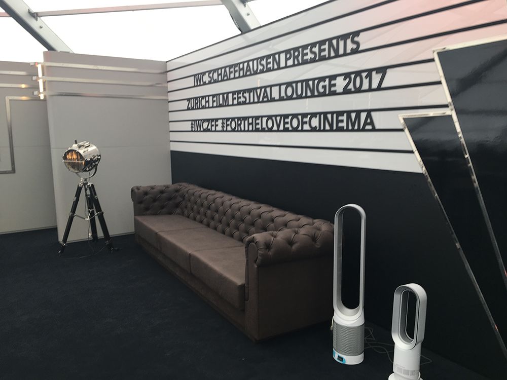 Ein Zimmer mit einer Couch und einem Ventilator und einer Wand, auf der „Die Liebe zum Kino“ steht