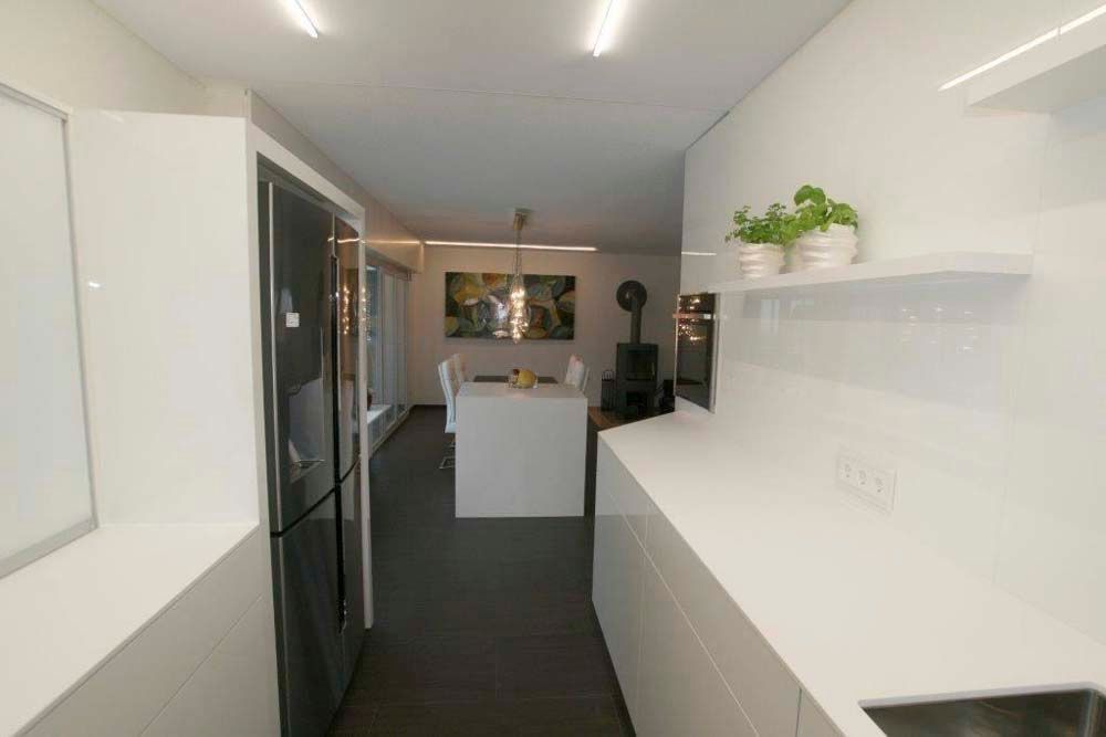 Eine Küche mit weißen Schränken und einem schwarzen Kühlschrank