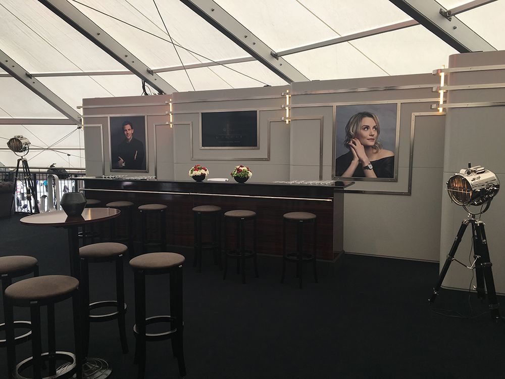 Ein Raum mit einer Bar und Hockern und einem Bild einer Frau an der Wand.