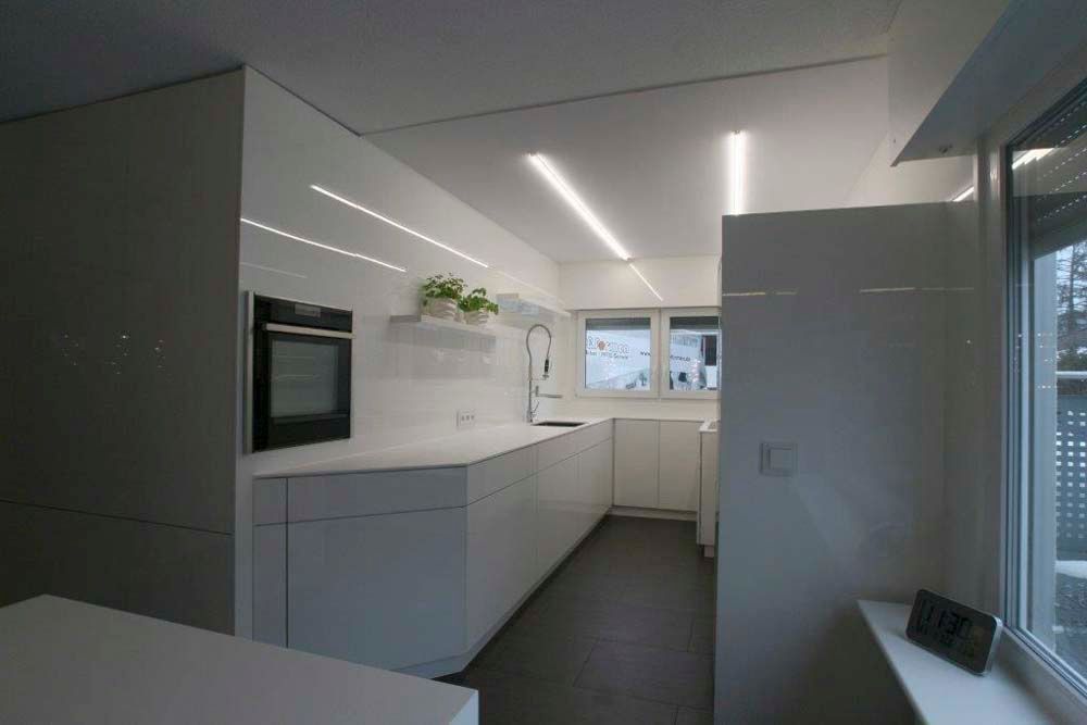 Eine Küche mit weißen Schränken und einem schwarzen Ofen