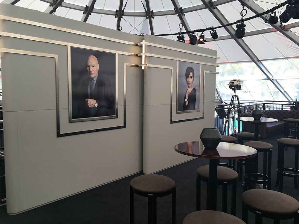 Ein Raum mit Tischen und Hockern und Bildern an der Wand