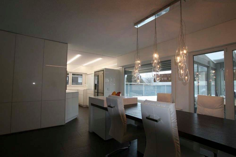 Ein Esszimmer mit Tisch und Stühlen und einer Küche im Hintergrund.