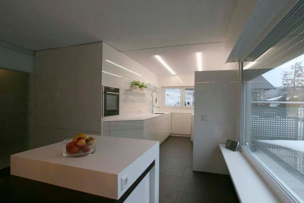 Eine Küche mit weißen Schränken und einer Obstschale auf der Theke