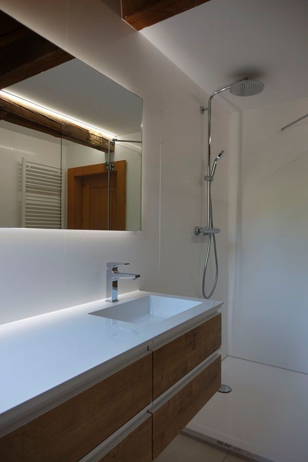 Ein Badezimmer mit Waschbecken, Spiegel und Dusche.