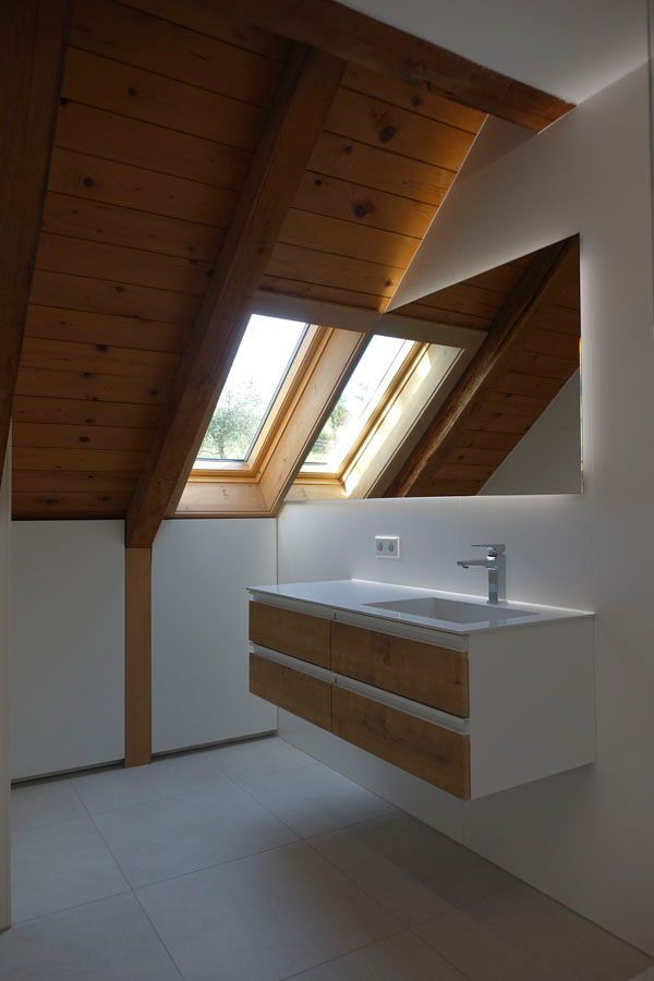 Ein Badezimmer mit Waschbecken, Spiegel und Oberlicht.