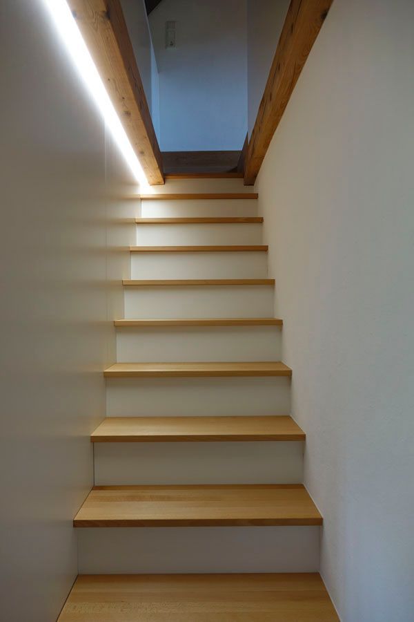 Eine Holztreppe führt hinauf zu einem Raum mit Holzboden.