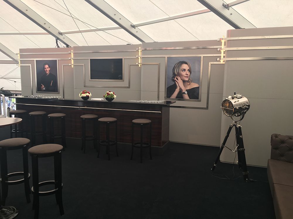 Eine Bar mit Hockern und einem Frauenbild an der Wand.