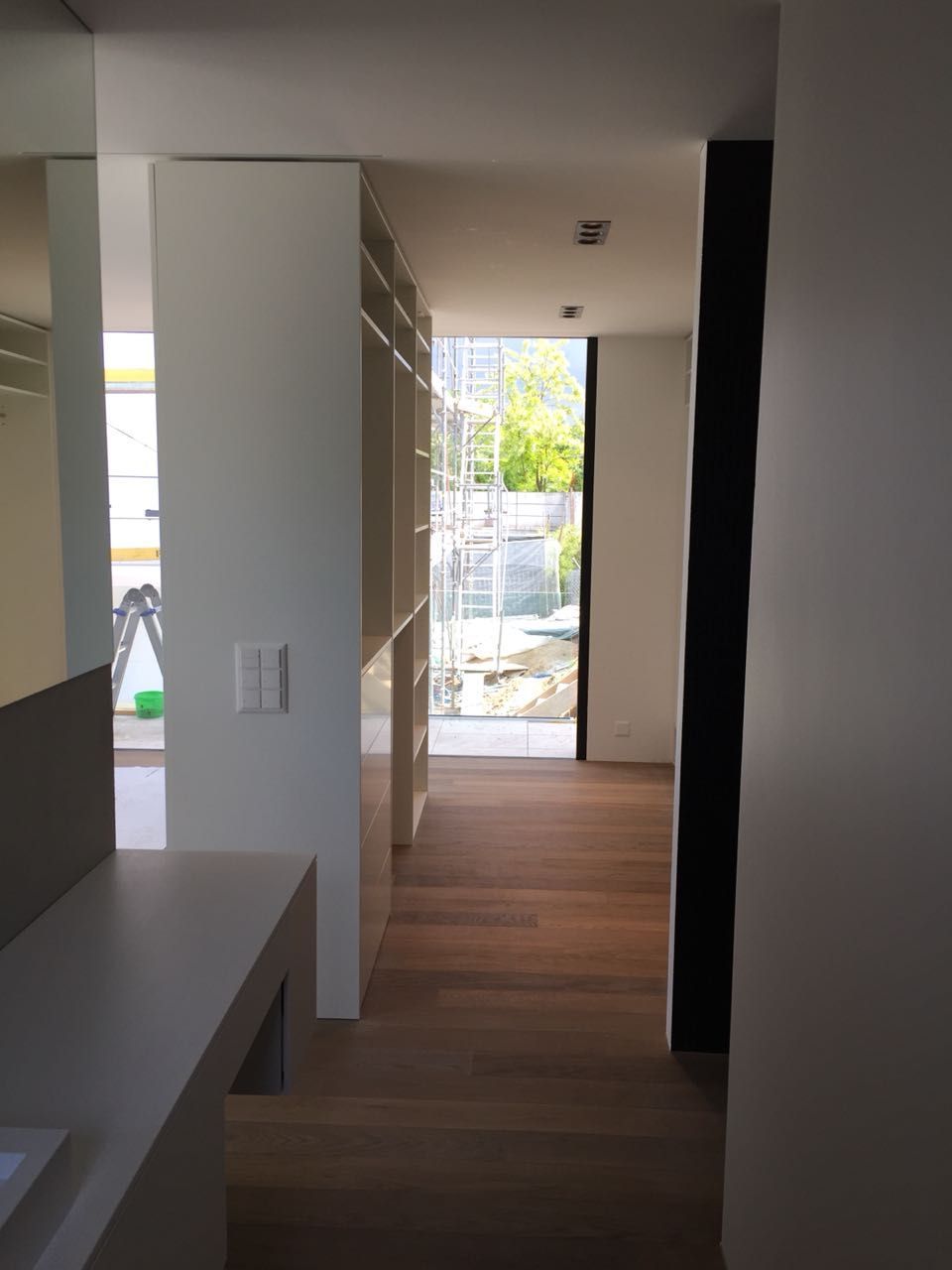 Ein Flur in einem Haus mit einem Waschbecken und einem Fenster