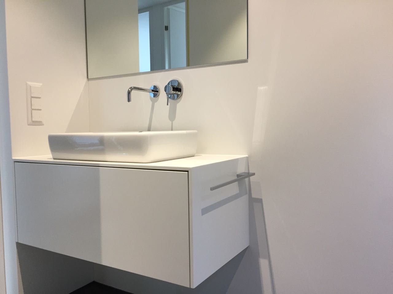 Ein Badezimmer mit Waschbecken und Spiegel an der Wand.