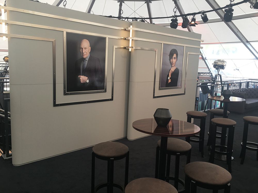 Ein Raum mit Tischen und Hockern und Bildern an der Wand