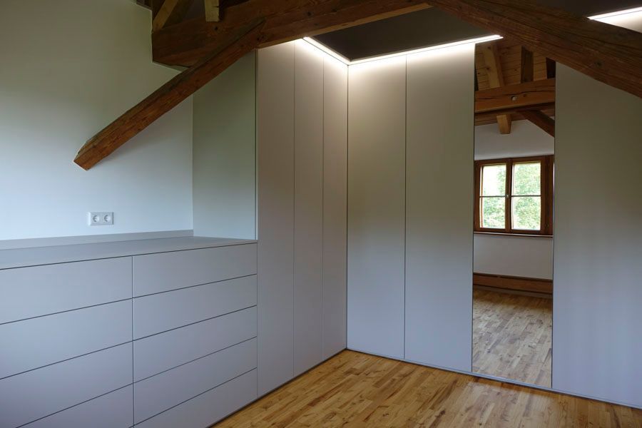 In der ecke des zimmers hängt ein großer spiegel.