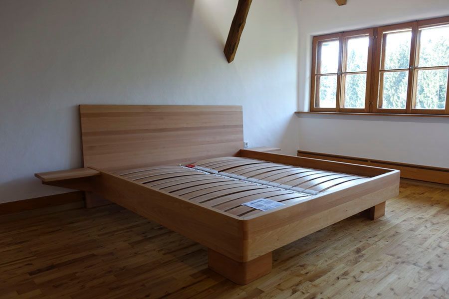 Ein Schlafzimmer mit einem Holzbett und zwei Fenstern