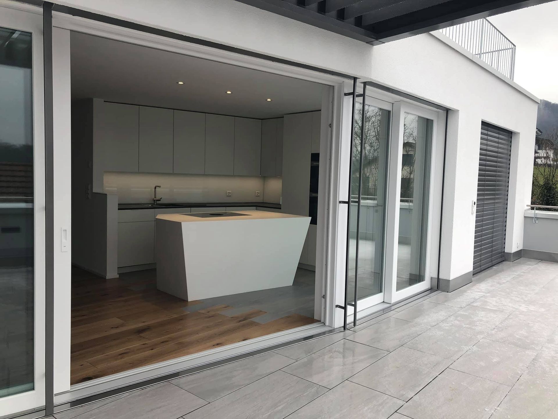 Eine Küche mit Glasschiebetüren, die auf einen Balkon führen.