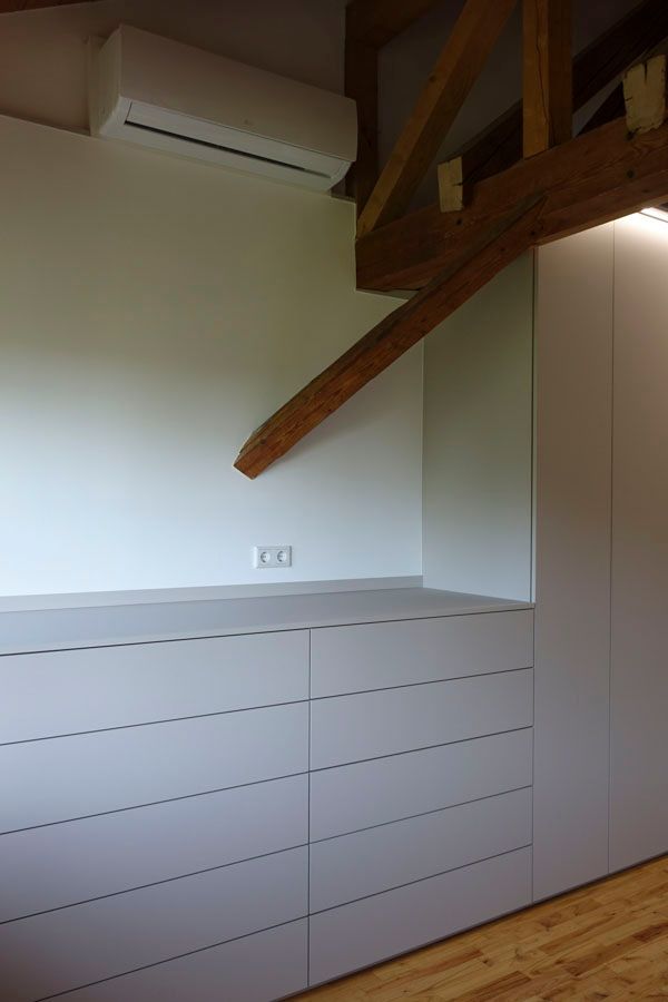 Ein Zimmer mit einer Kommode und einer Holztreppe.