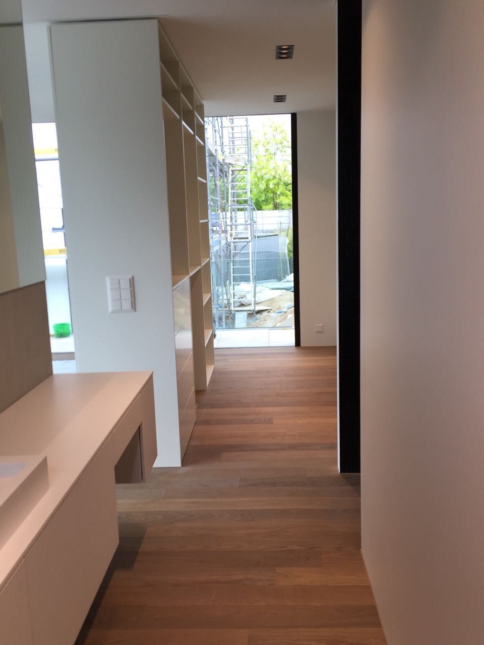 Ein Flur mit Holzboden und weißen Wänden