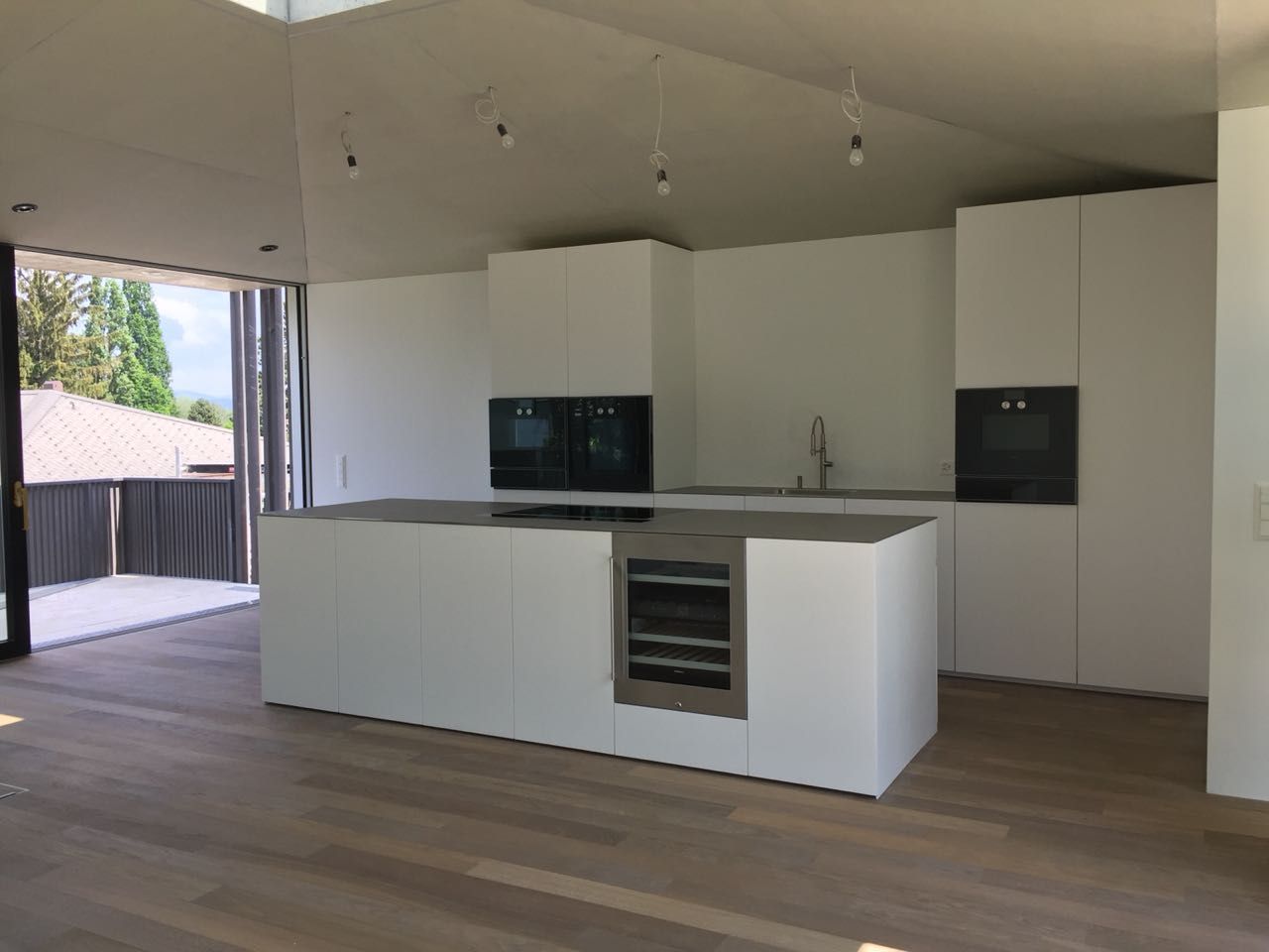 Eine leere Küche mit weißen Schränken und einer großen Insel