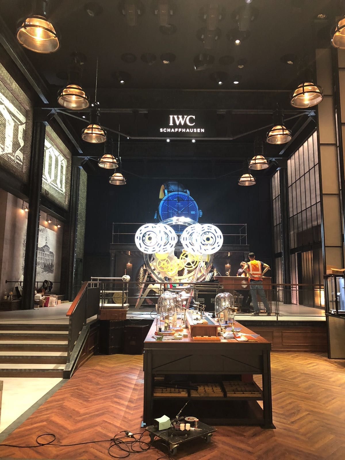 Ein großer Raum mit einem Tisch und einem großen Bildschirm, der von der Decke hängt.