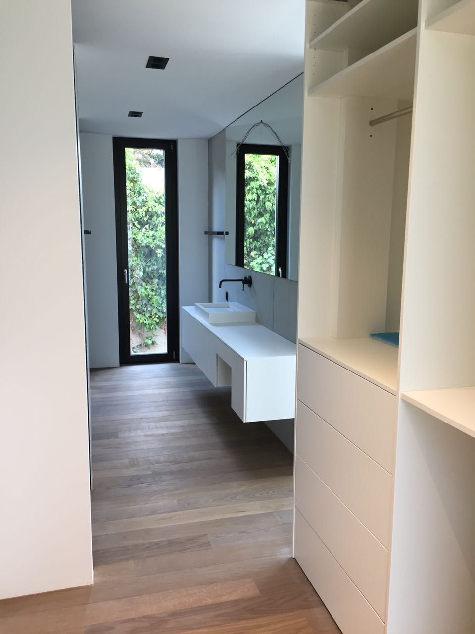 Ein Badezimmer mit Waschbecken und großem Fenster