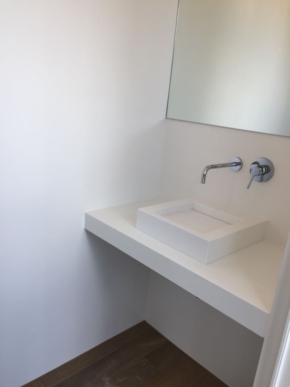 Ein Badezimmer mit Waschbecken und Spiegel an der Wand