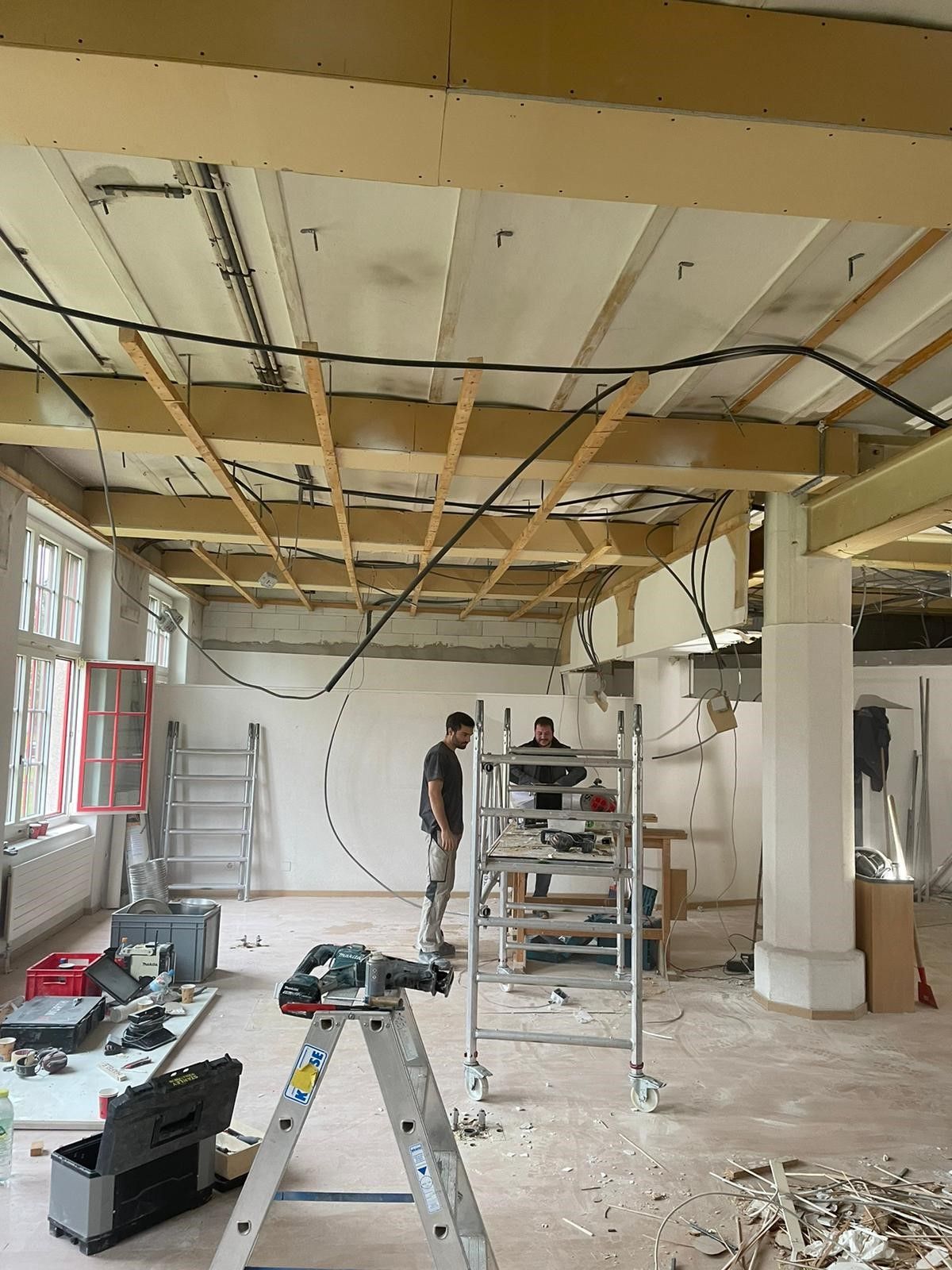 Ein Mann steht auf einer Leiter in einem Raum im Bau.