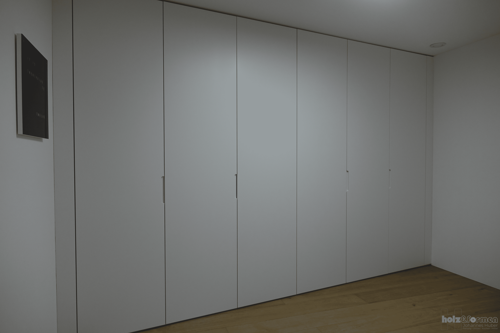 Ein Raum mit vielen weißen Wänden und einem Holzboden.