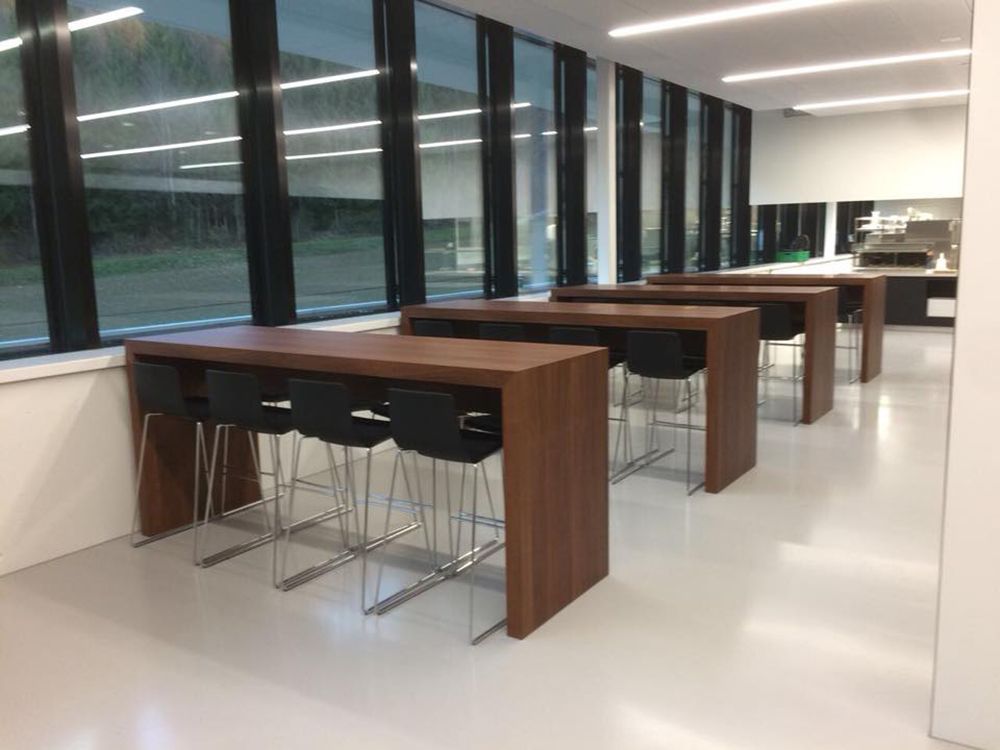 Ein Raum mit vielen Fenstern und Tischen und Stühlen