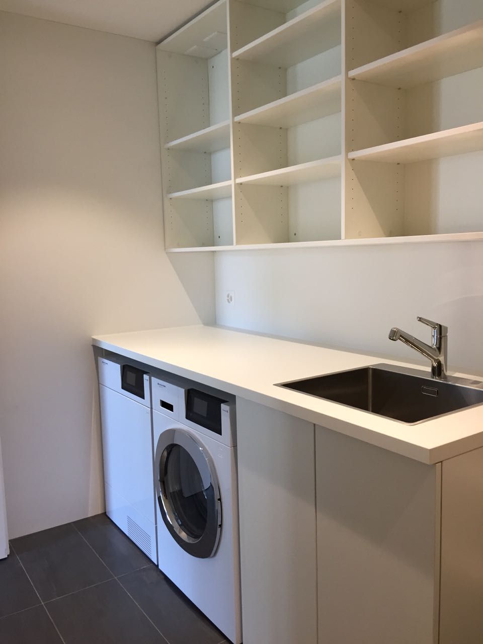 Eine Waschküche mit Waschmaschine, Trockner und Waschbecken
