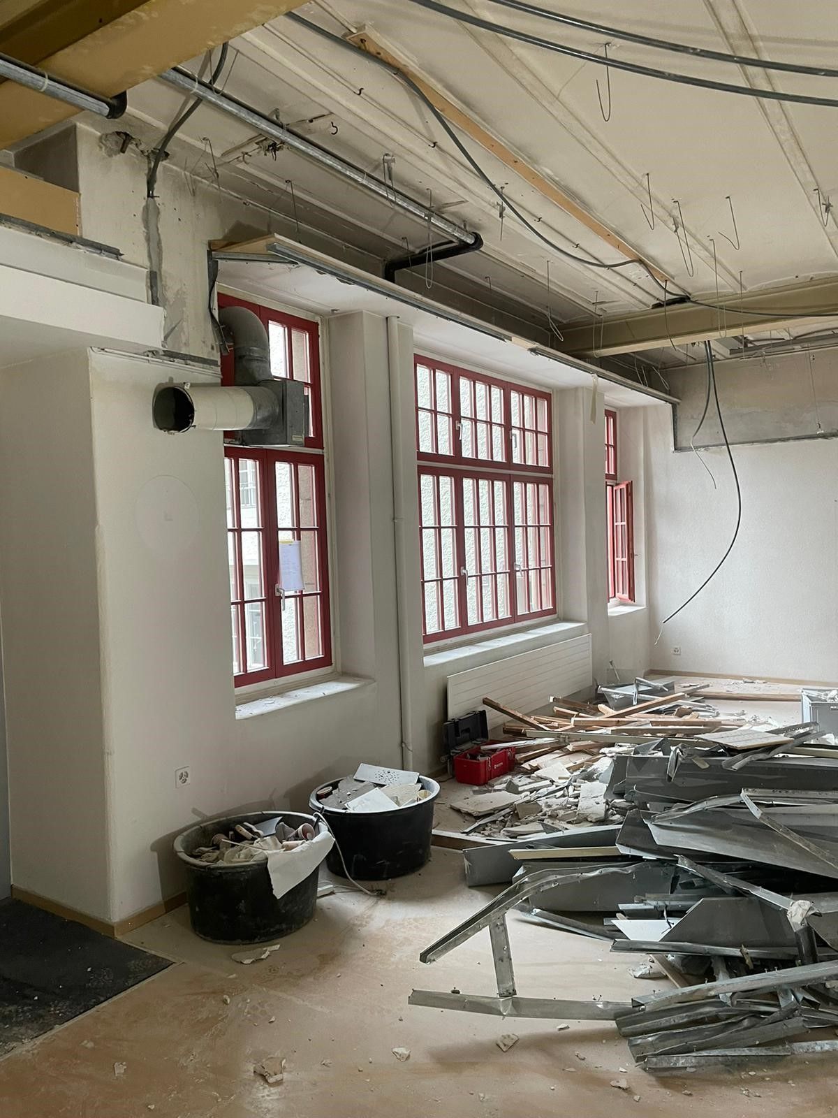 Ein Raum mit viel Gerümpel und vielen Fenstern.