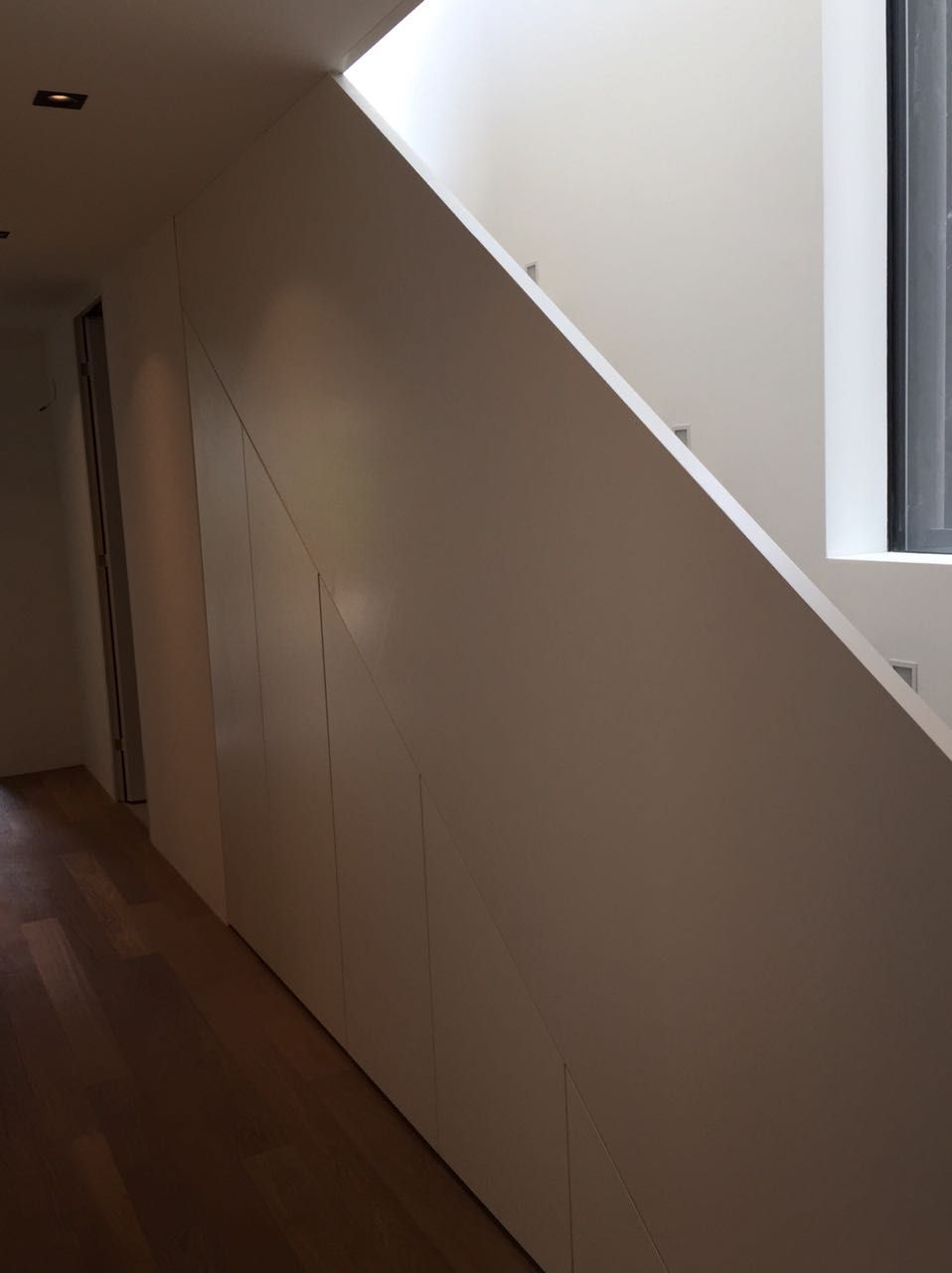 Ein Flur mit einer Treppe und einem Fenster