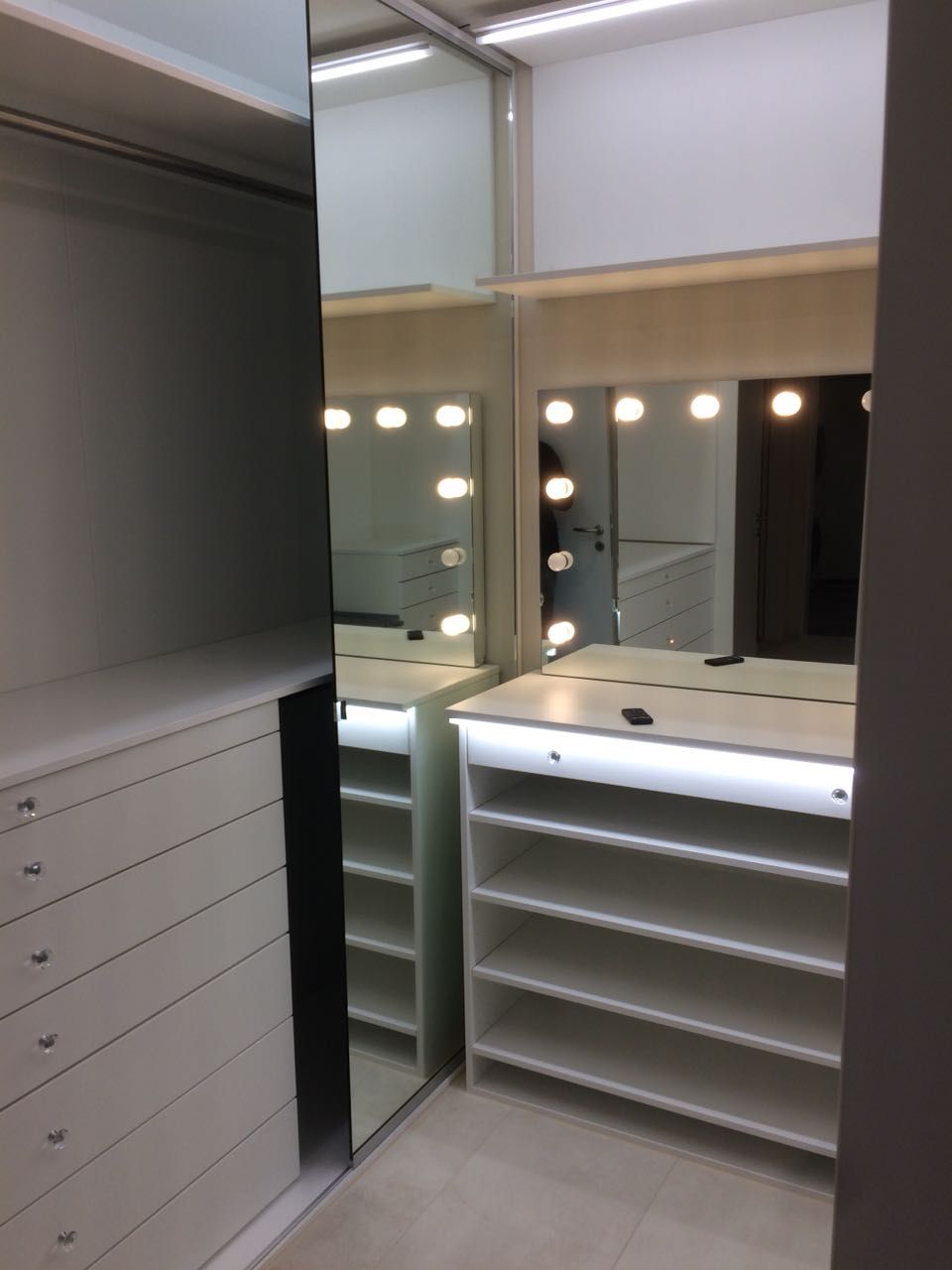 Ein begehbarer Kleiderschrank mit Spiegel und Regalen