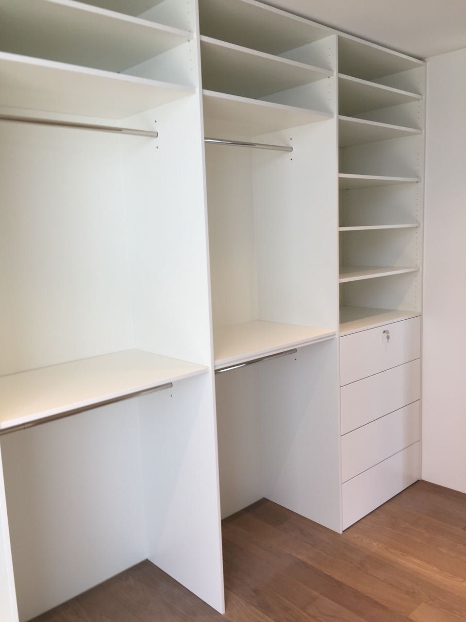 Ein begehbarer Kleiderschrank mit vielen Regalen und Schubladen