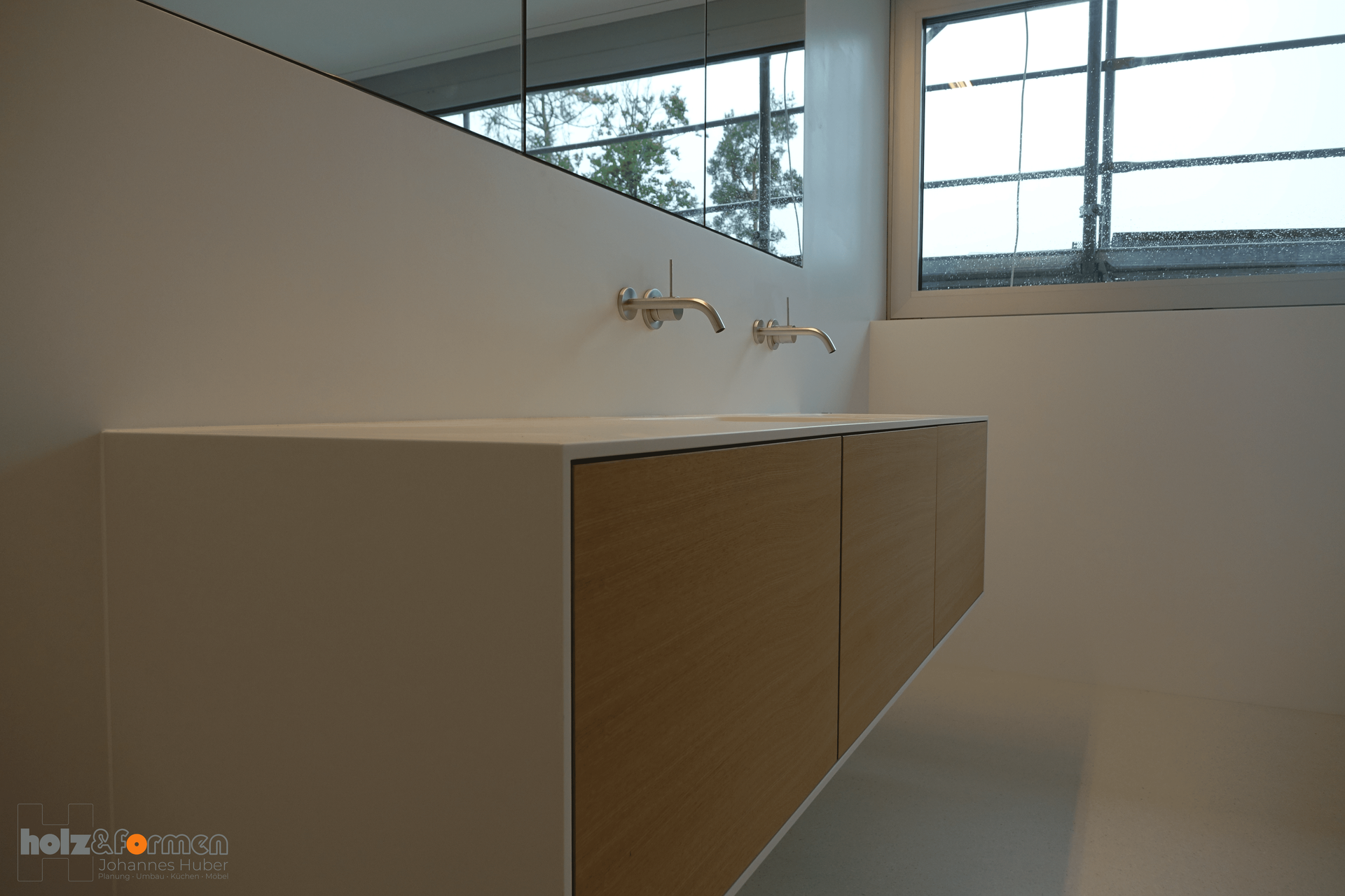 Ein Badezimmer mit Waschbecken, Spiegel und Fenster