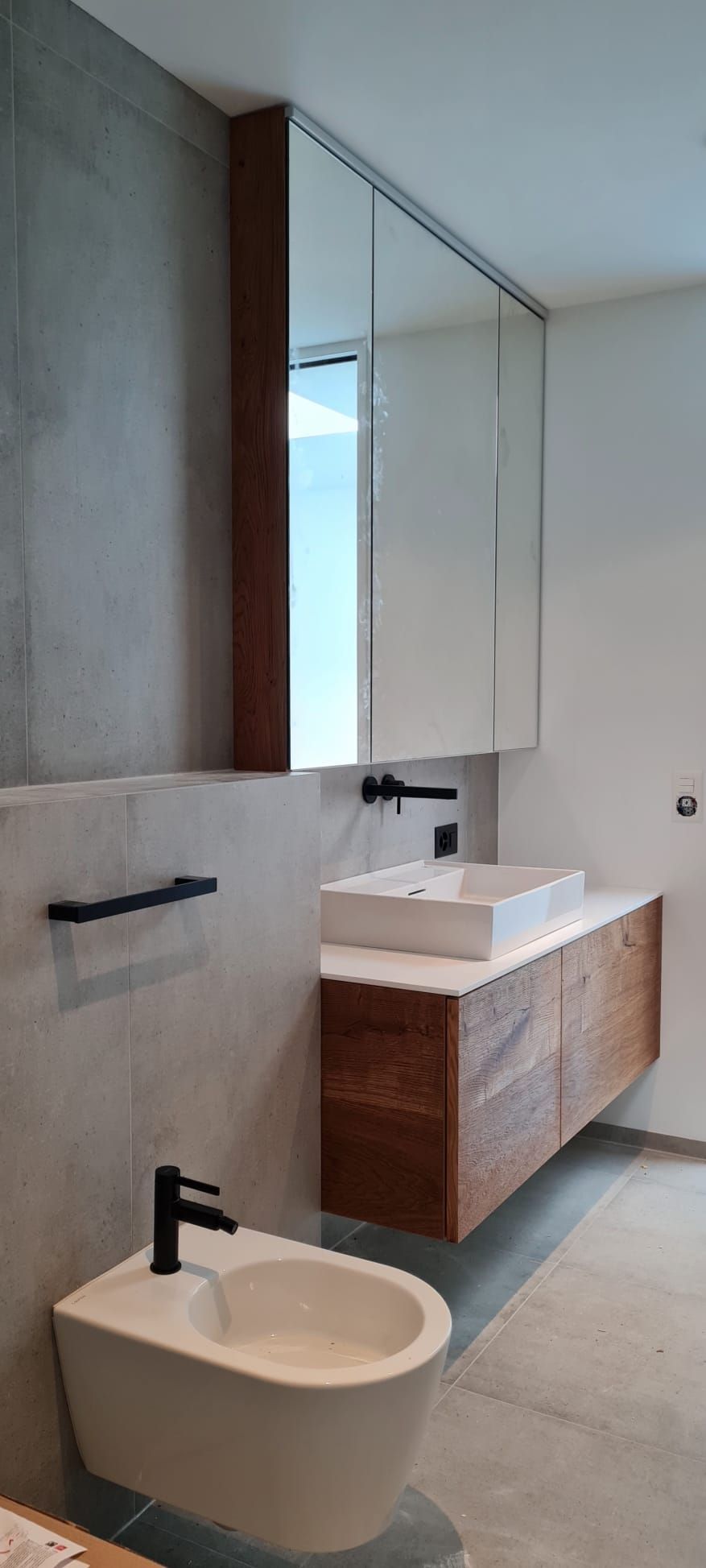 Ein Badezimmer mit Bidet, Waschbecken und Spiegel.