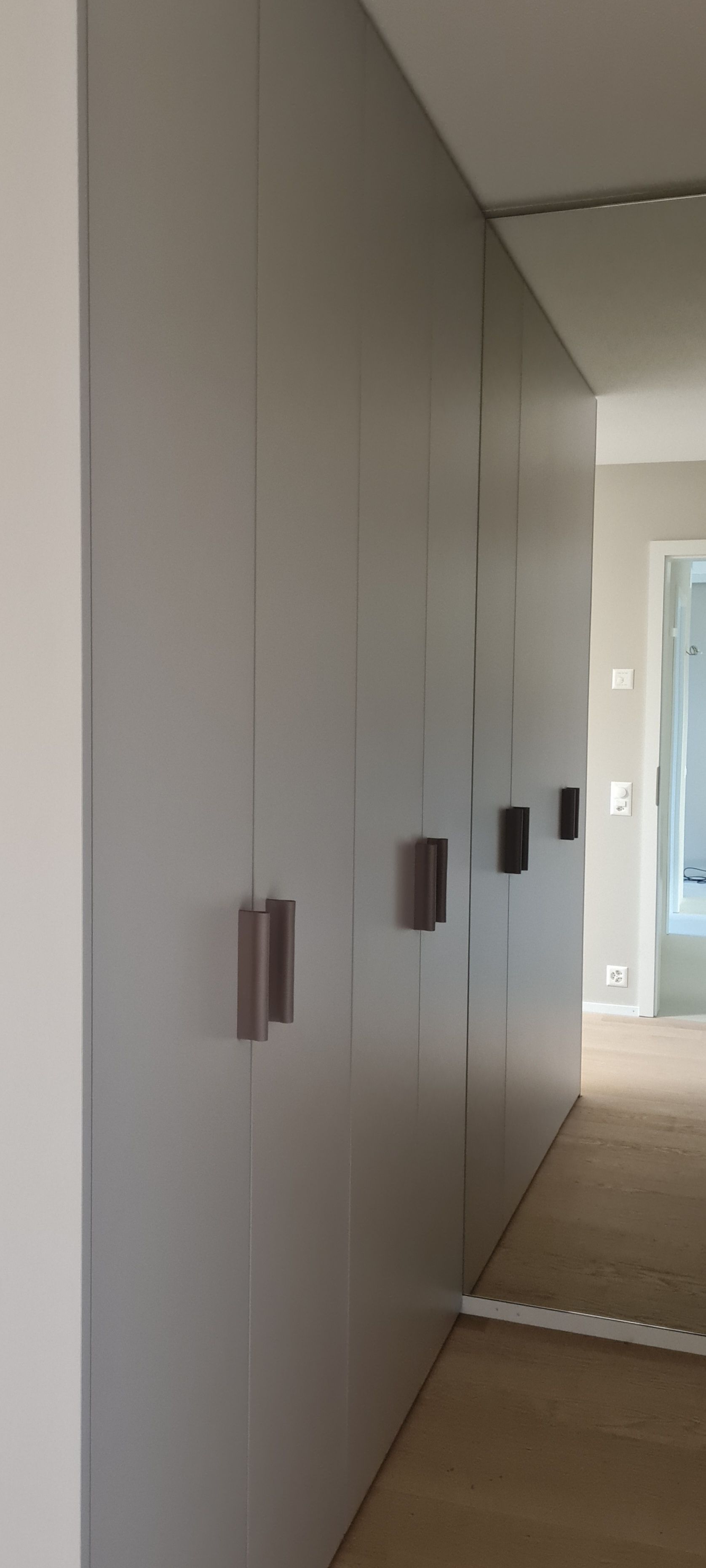 Ein Flur mit Spiegel und einem Schrank mit vielen Türen.
