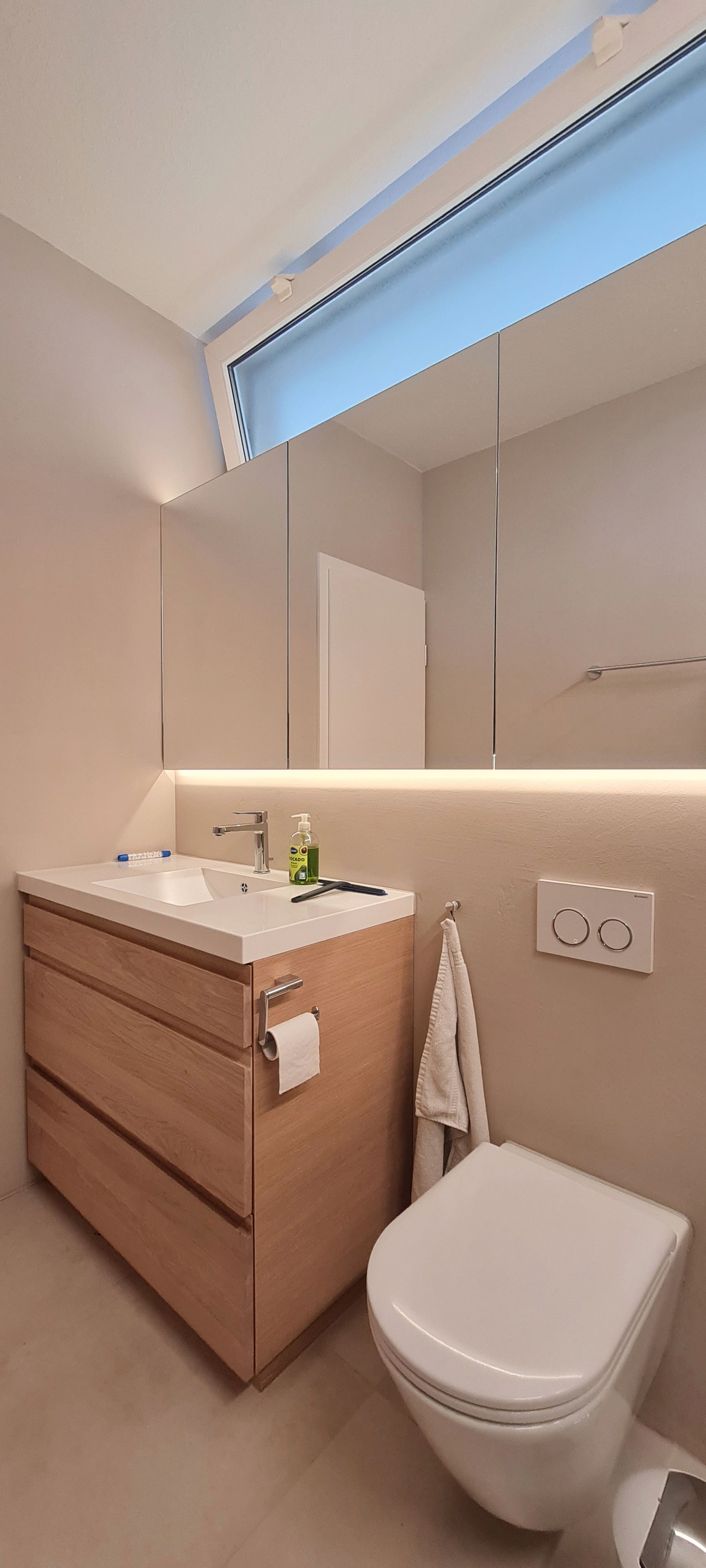 Ein Badezimmer mit Waschbecken, Toilette und Spiegel.