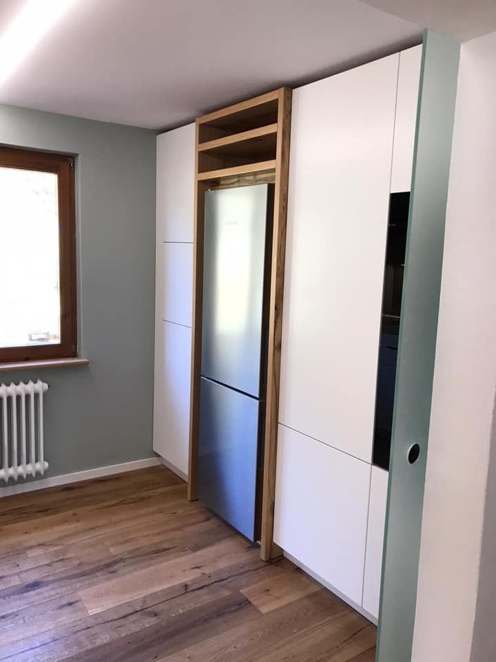 Eine Küche mit weißen Schränken und einem Edelstahlkühlschrank.