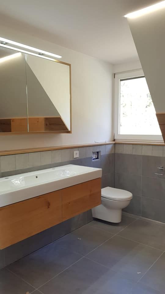 Ein Badezimmer mit Waschbecken, Toilette und Spiegel.