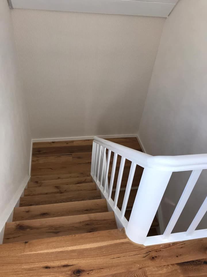 Eine Treppe mit Holzstufen und einem weißen Geländer