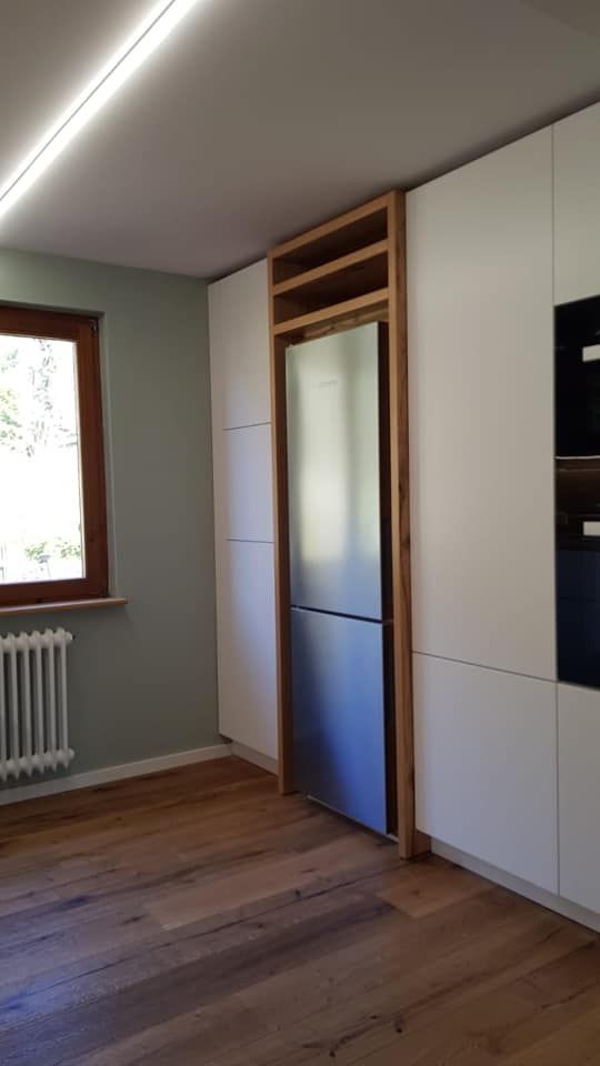 Eine Küche mit weißen Schränken und einem Edelstahlkühlschrank.