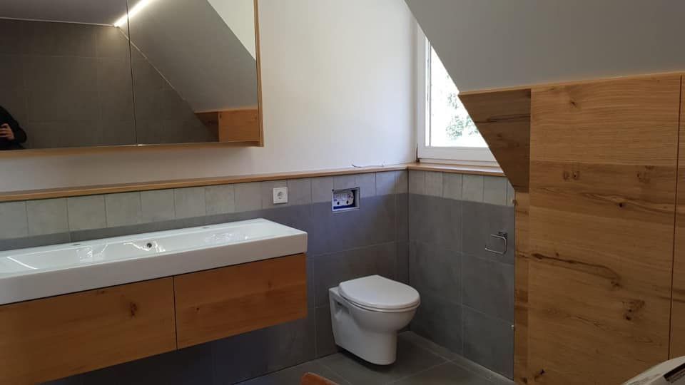 Ein Badezimmer mit Toilette, Waschbecken und Spiegel.