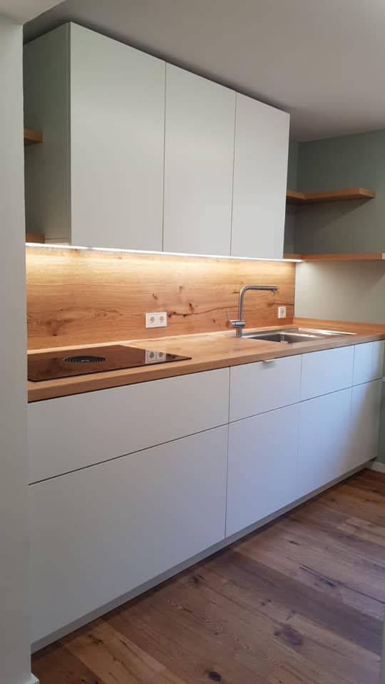 Eine Küche mit weißen Schränken und Holzarbeitsplatten.