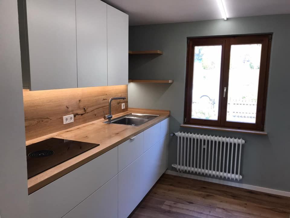 Eine Küche mit Spüle, Herd und Fenster.