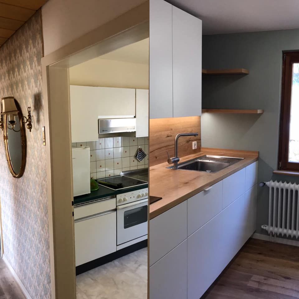 Eine Küche mit weißen Schränken und Holzarbeitsplatten