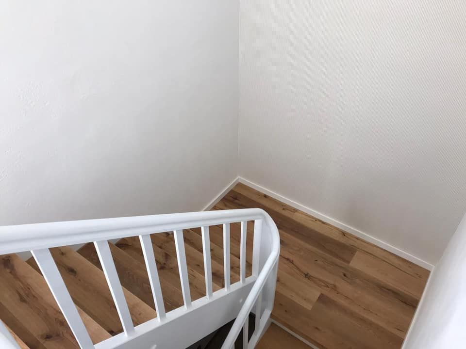 Eine Treppe mit weißem Geländer und Holzboden