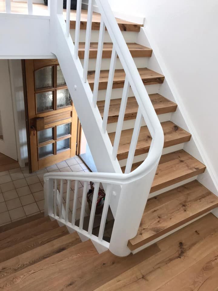 Eine Treppe mit Holzstufen und einem weißen Geländer