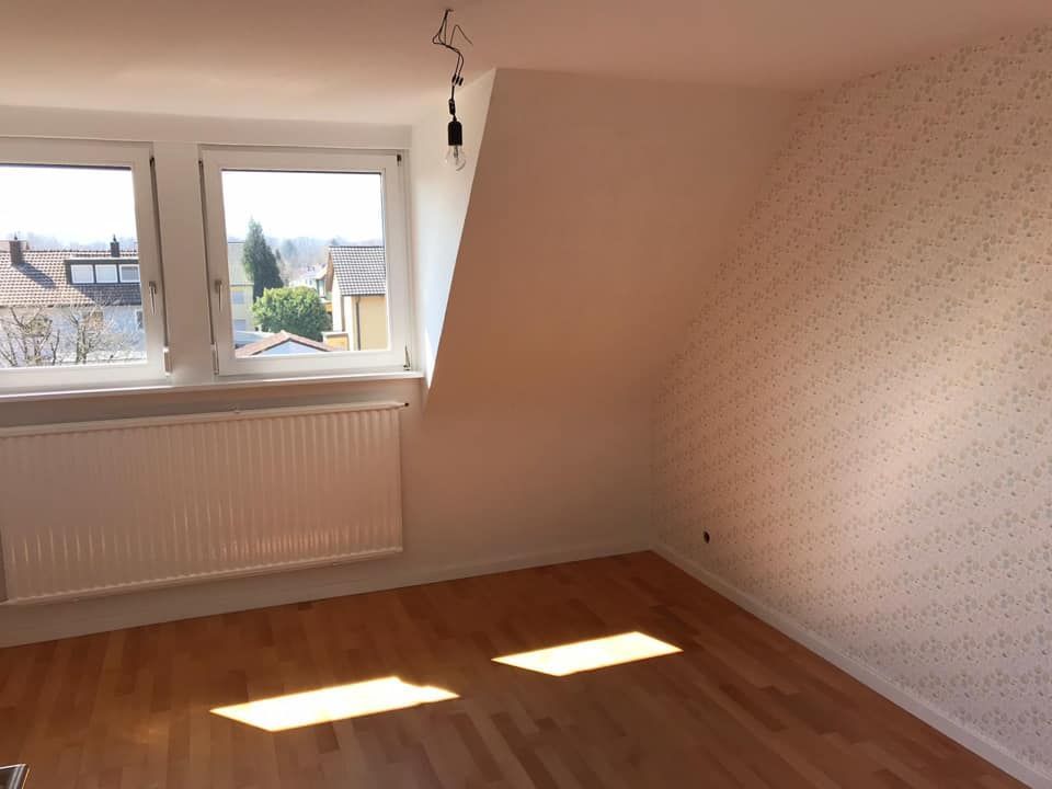 Ein leerer Raum mit einem Fenster und einem Heizkörper